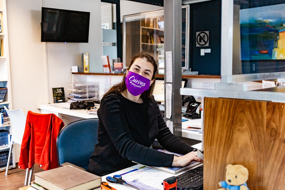 Frau mit Maske im Büro
