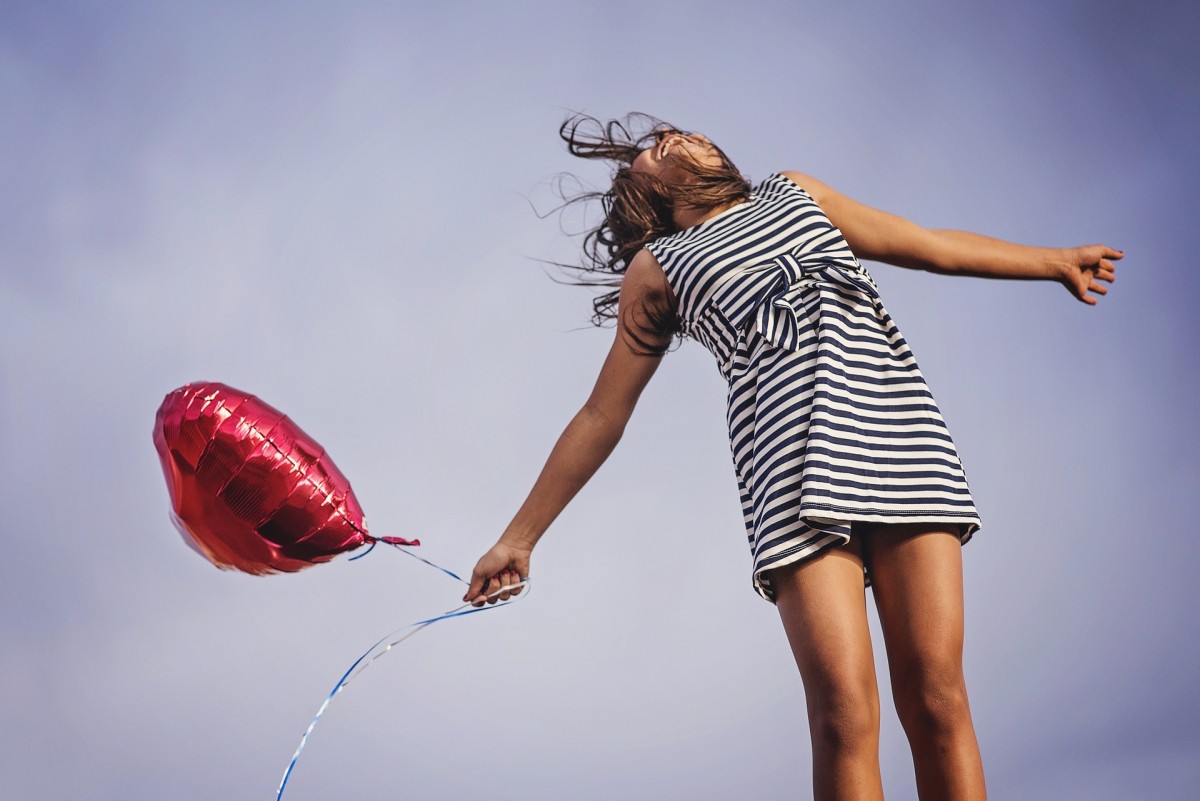 Frau mit Luftballon in Herzform